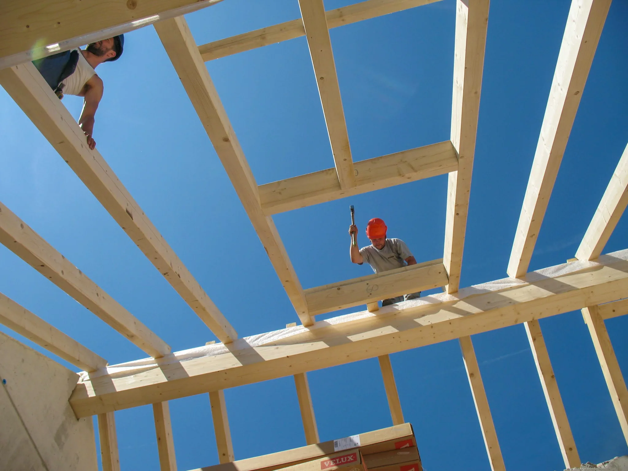 Zimmermann beim Aufstellen eines Dachstuhls